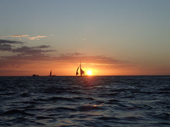 Boat sailing in sea at sunset