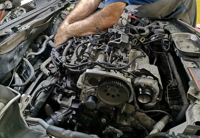 Midsection of mechanic repairing car