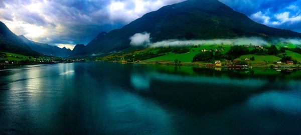 Scenic view of lake and mountains against blue sky