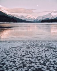 Scenic view of lake and snowcapped mountains against sky