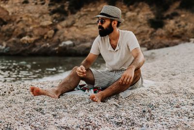 Young man sitting on rock