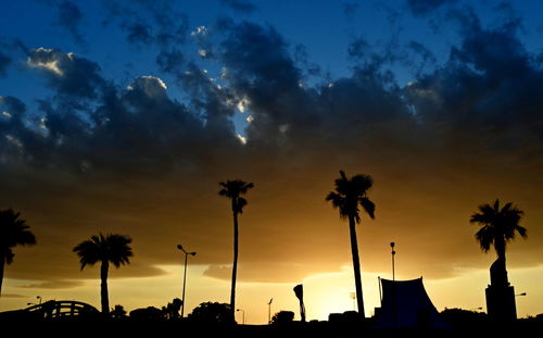 Silhouette palm trees against sky during sunset