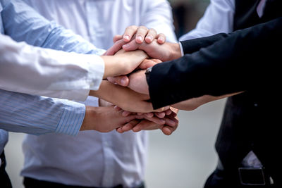 Business people stacking hands outdoors