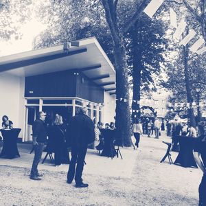 People walking on footpath by building in city