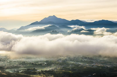 Aerial view of majestic mountains against sky during sunset