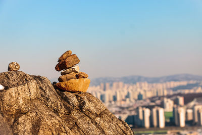 Stone balancing atop a fortress overlooking a city 