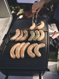 Fresh sausage and hot dogs grilling outdoors on a gas barbecue grill. concept picnic