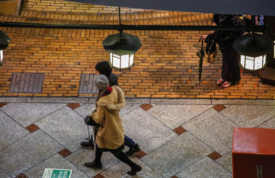 Rear view of man walking on cobblestone