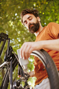 Side view of young man with bicycle