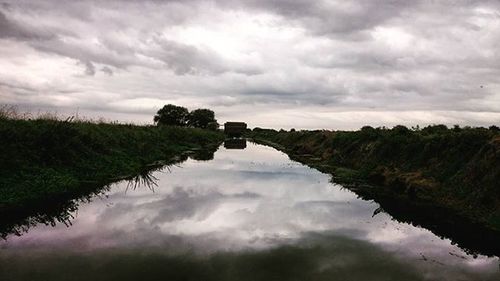 Scenic view of lake against cloudy sky