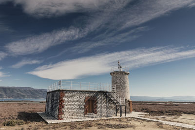 View of abandoned building against cloudy sky
