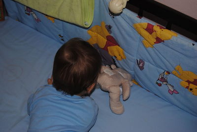 Baby boy playing in crib at home