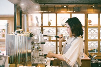 Little girl barista making coffee.