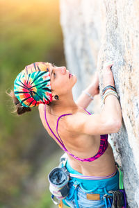 Young woman climbing on rock outdoors