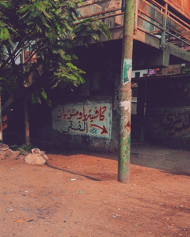 built structure, architecture, building exterior, text, graffiti, western script, tree, communication, abandoned, wall - building feature, day, outdoors, house, no people, information sign, sign, building, street, capital letter, non-western script