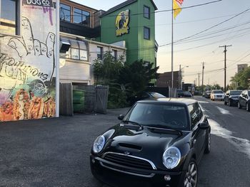 Cars on road by buildings in city