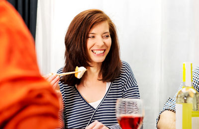 Portrait of a smiling young woman drinking drink