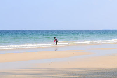 Woman on beach against clear sky