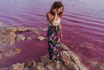 Woman standing on rock at beach