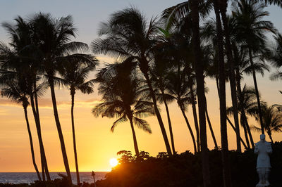 Silhouette palm trees against sky at sunset