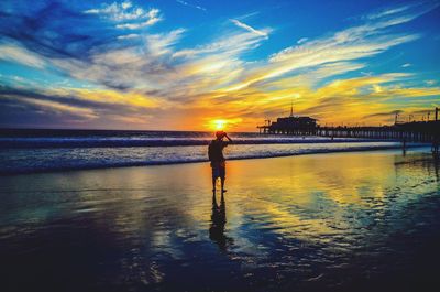 Silhouette of people on beach at sunset