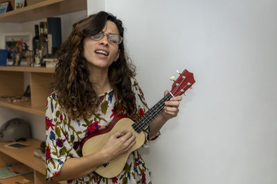 Portrait of young woman playing guitar