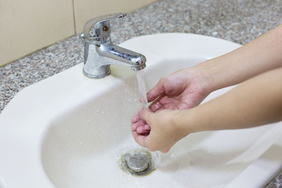 High angle view of woman washing hands in sink