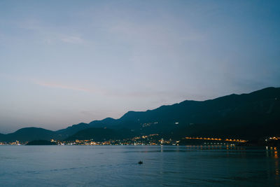 Scenic view of sea by mountains against sky