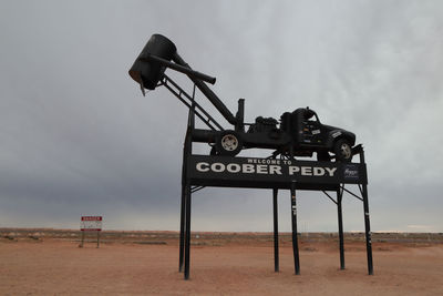 Information sign on field against sky