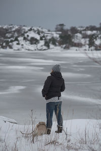 Rear view of person standing on snow covered land