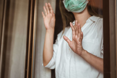 Midsection of woman standing by window