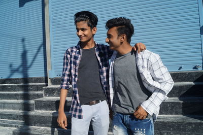 Young man standing against building