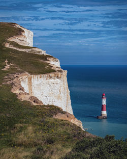 Lighthouse by sea against sky