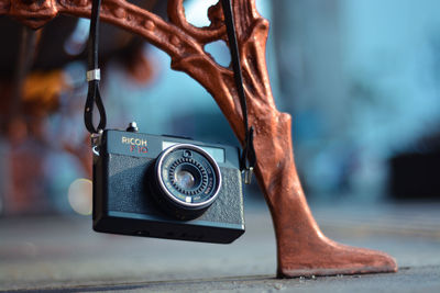 Close-up of camera hanging on metal chain