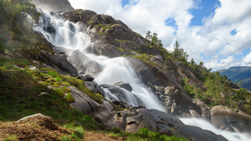 Low angle view of waterfall against sky