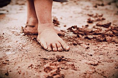 Low section of child standing on sand