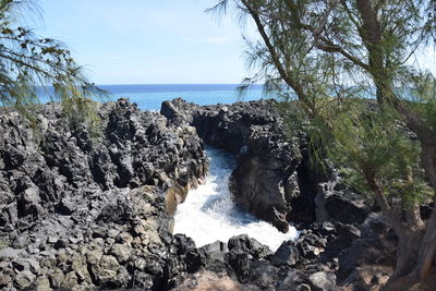 Panoramic shot of rocks by sea against sky