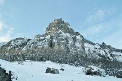 Low angle view of snowcapped mountain against sky