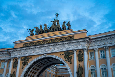 Low angle view of statues on building against sky