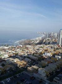 Aerial view of city by sea against sky