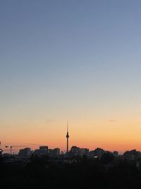 Low angle view of buildings against clear sky during sunset