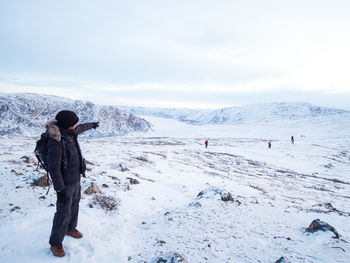 Full length of woman on snow covered landscape against sky