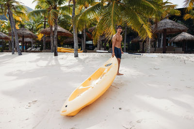 Rear view of woman in boat on beach