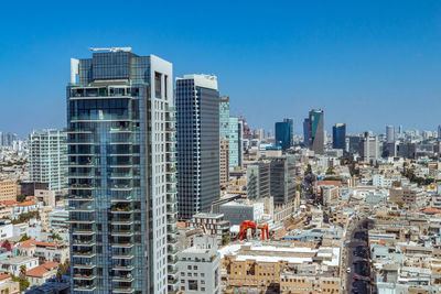 Modern buildings in city against clear blue sky