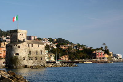 Buildings by sea against sky in city