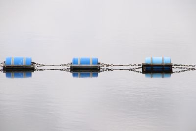 Wooden post on pier by sea against sky