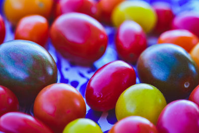 Yellow, red, orange, and dark green heirloom cherry tomatoes on blue spatter enamelware plate