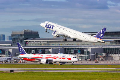 Airplane on airport runway against sky