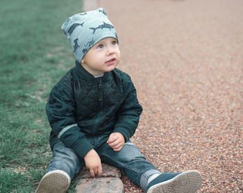 Portrait of cute boy sitting on field