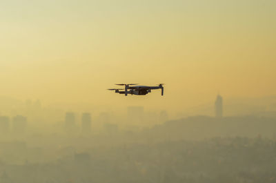 Airplane flying against sky during sunset